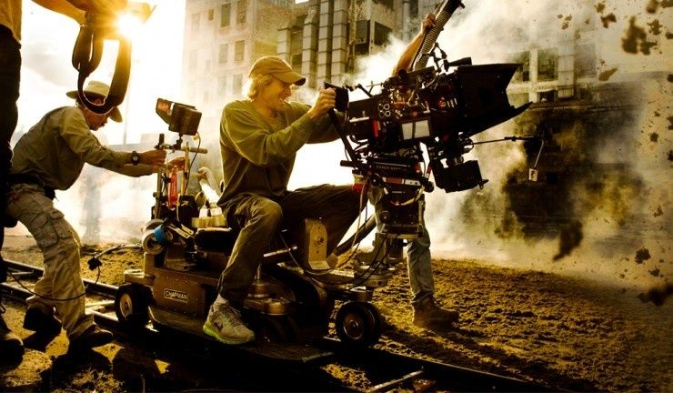 Film crew operating a camera dolly on a dusty, smoke-filled set