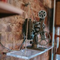 Vintage film projector displayed against an exposed brick wall